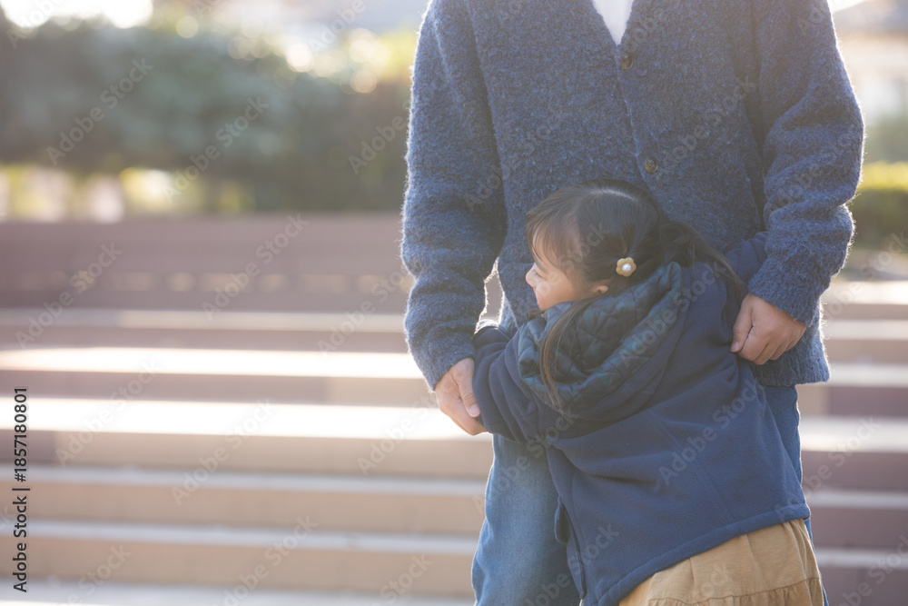 Φωτογραφία 秋の紅葉の公園でパパに抱き着く笑顔の子どもの顔無し　愛着形成など子育てのイメージ
