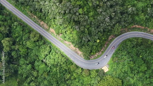 Aerial Top View of Winding Forest Road; Concept of Sustainable Future Mobility and Smart Infrastructure in Nature.