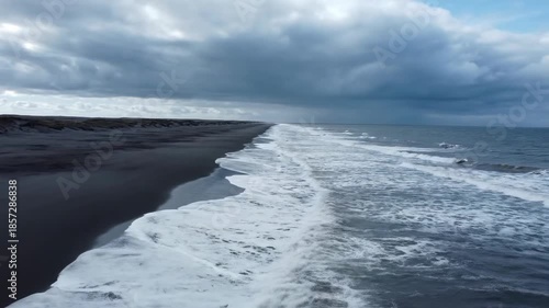 Wallpaper Mural Dark storm clouds loom above the turbulent ocean waves crashing onto the shore while the wind whips white foam across the dramatic coastal seascape Torontodigital.ca