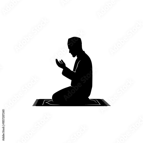 Silhouette of a man praying in a kneeling position on a mat