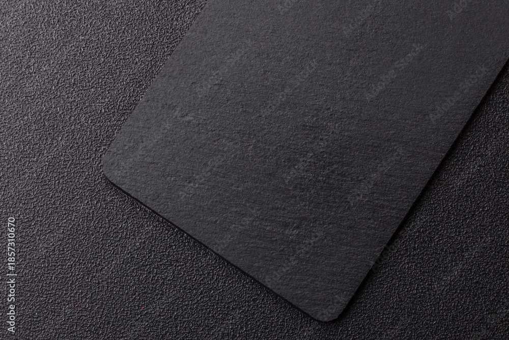Fototapeta premium A black slate stone board or plate, an empty kitchen utensil. A black slate board
