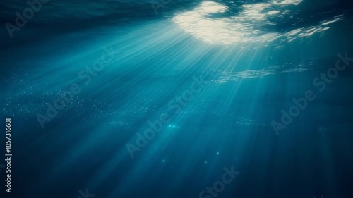 Underwater light rays in blue ocean water, tranquil and serene marine environment.