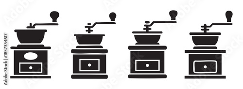 Four manual coffee grinders are displayed in a row, showcasing different classic designs of these essential kitchen tools for brewing fresh, aromatic beverages.