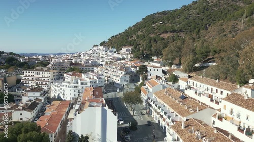 Aerial fly over hillside town of Mijas Pueblo with white washed architecture and Mediterranean charm, Malaga, Spain.