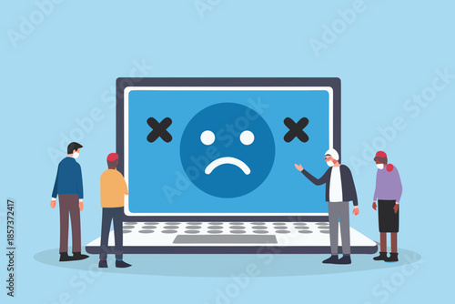 People observing a laptop displaying a sad face and error symbols