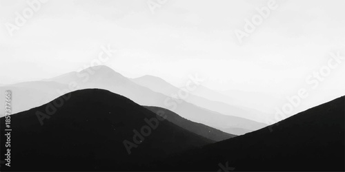 Misty mountain landscape with hills and sunrise sky