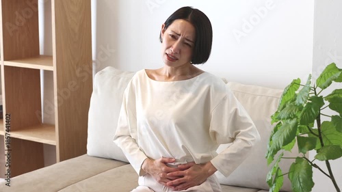 お腹を押さえる女性