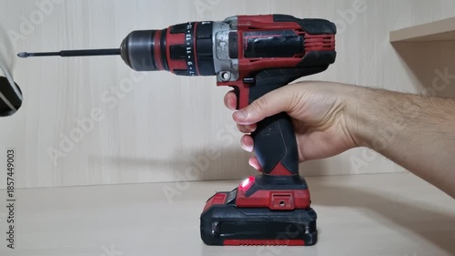 Side profile view of a red cordless power drill running with a bit installed showing the motor speed and stability