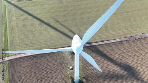 Aerial Wind Turbine Casting Shadow Across Agricultural Fields