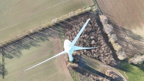 Aerial Wind Turbine Casting Shadow Across Agricultural Fields