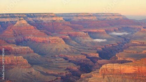 Vast canyon glowing with golden light at dawn, cinematic aerial perspective