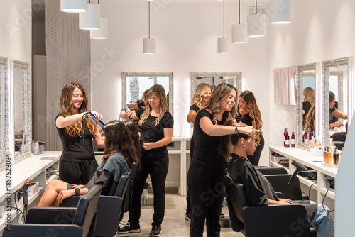 Foto Hairdressers styling client hair in modern salon