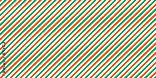 Christmas seamless pattern. Red and green diagonal stripes background. Candy cane repeating decoration wallpaper. Winter holiday lines backdrop.