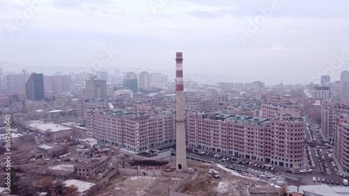 Aerial view of a smoke stack from a former factory industrial zone gentrified into a residential district