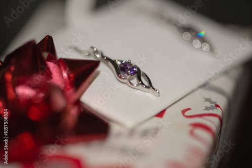 Silver earrings on a Christmas paper wrapped box.