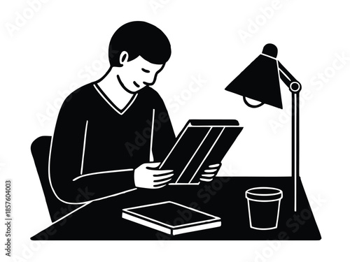 Man reading book under desk lamp