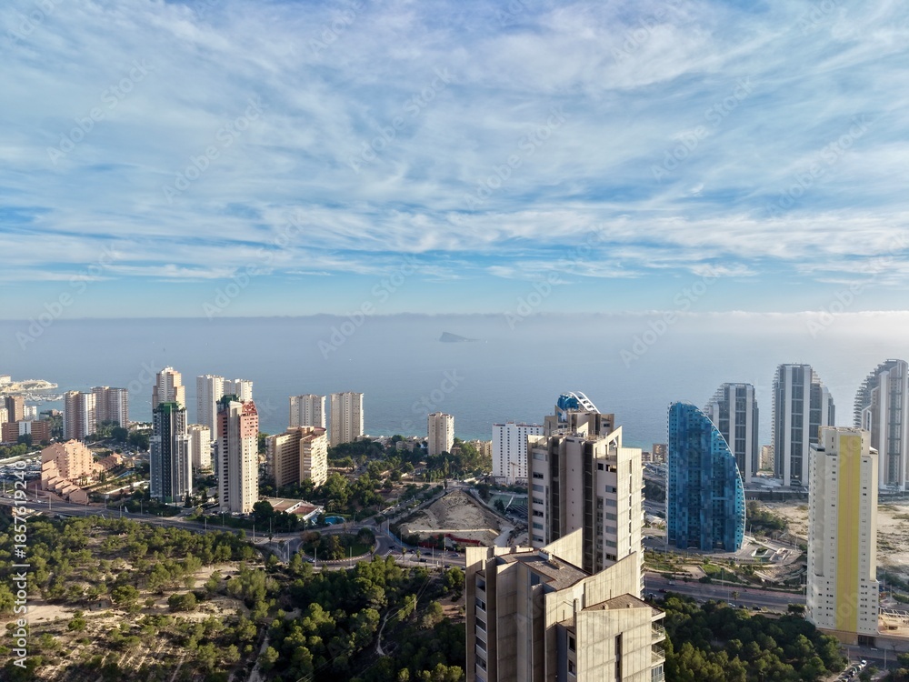 Fototapeta premium sunny midday panorama displays towering structures and lively coastal residential environment