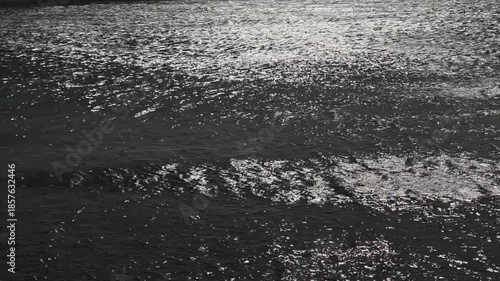 soft waves and wind ripples in dark water of the Atlantic Ocean with bright sunlight reflections