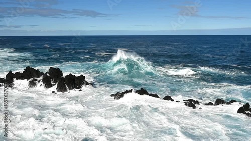 Waves of the blue Atlantic Ocean crashing into rocks on the coast. Porto Moniz, Madeira, Portugal