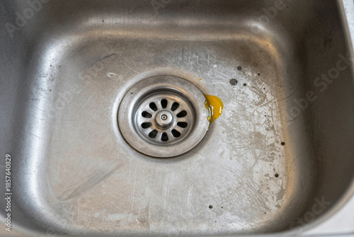 Stainless steel sink with a drain in it.