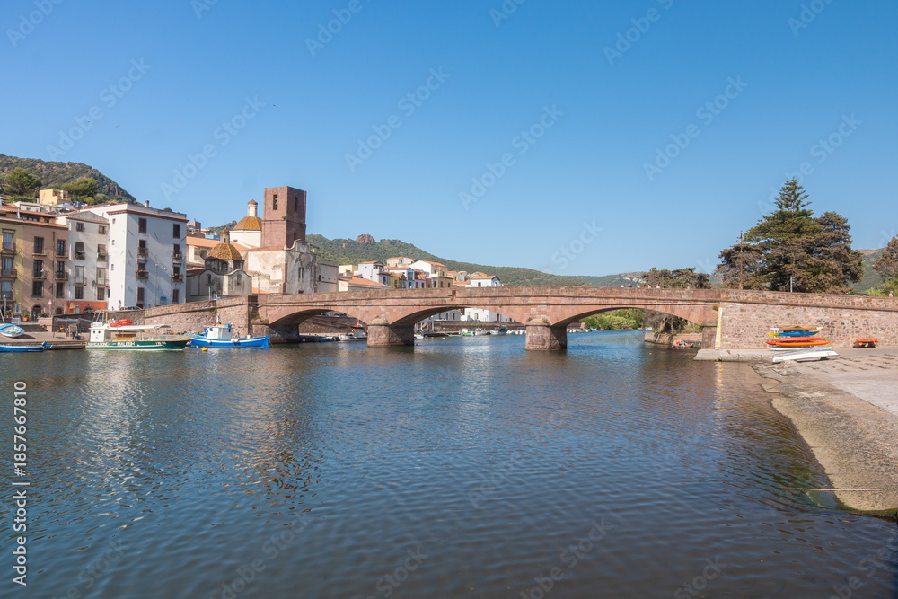 Fototapeta premium Stone Bridge Over Calm River, Bosa, Italien