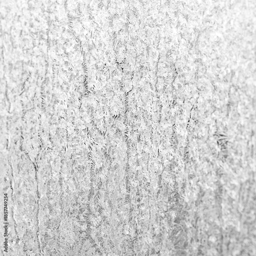 Fototapeta premium Frosted ice crystal texture on a white gray surface, abstract winter background