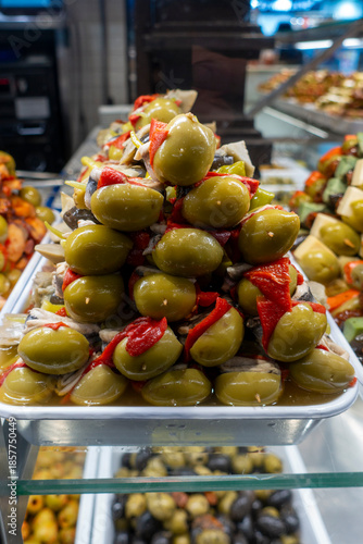 Snack shop counter with Gildas pinchos, which include olives, anchovies, and chili peppers.