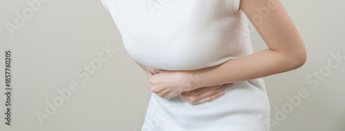 Flatulence asian young woman intolerance hand in stomach ache, suffer from food poisoning, abdominal pain and colon problem, gastritis or diarrhoea when at home. Patient belly, abdomen or inflammation