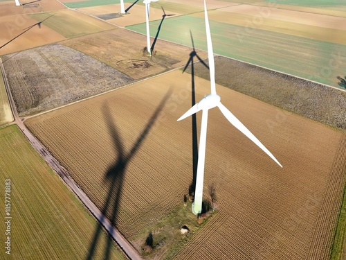 Aerial Wind Turbine Casting Shadow Across Agricultural Fields