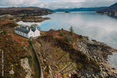 Bild auf Leinwand Beautiful Traditional Cottages and Lighthouse on Eilean Bàn Island, Isle of Skye, on a Sunny Winter Morning