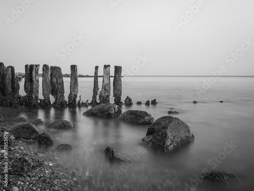 Stones and planks on the beach washed by water