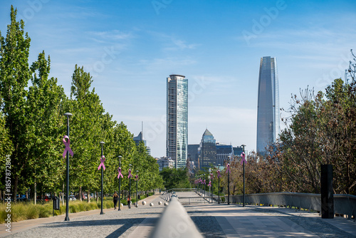 Ein Fußweg durch einen Park mitten in Santiago de Chile mit Blick auf die Skyline mit modernen Hochhäusern