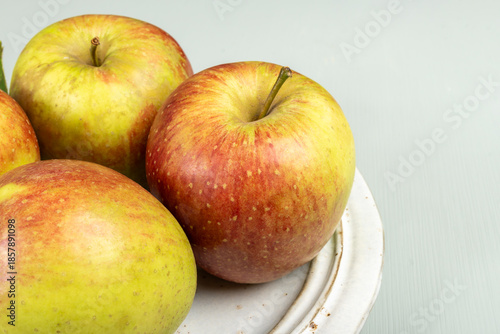 New harvest of french sweet red green apples, tasty healthy fruits on plate