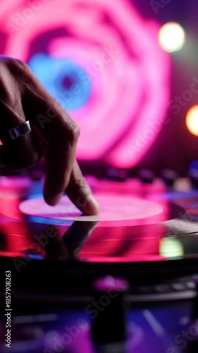 DJs hand on a vinyl record, mixing music with vibrant neon lights in the background.