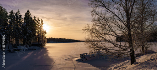 Winter Sunrise over Frozen Lake with Snow Covered Trees