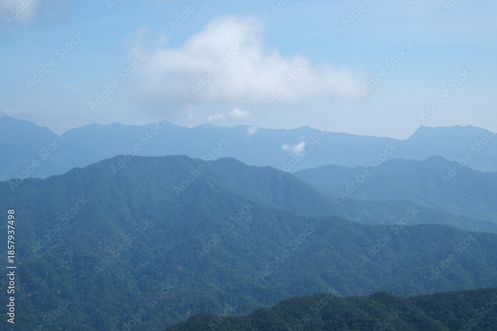 Obraz premium Vietnam Danang Misty mountains and lush forest view from Ba Na Hills near Da Nang Vietnam panoramic scenic landscape with clouds fog and tropical greenery.