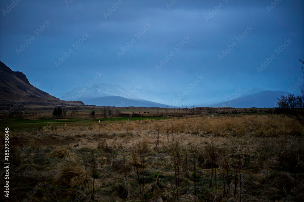 Fototapeta premium Misty Mountain Peaks Over the Fields of Akranes, Iceland