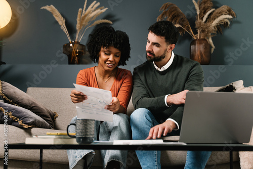 Couple reviewing household bills together while planning finances and domestic economy at home