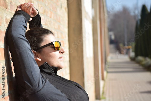 Woman with visual disabilities exercising in the park and stretching