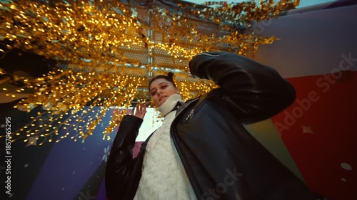 Chic street pose captured against illuminated urban night backdrop