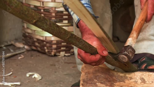 Worker Shaping Long Wood with Adze While Holding It with Foot