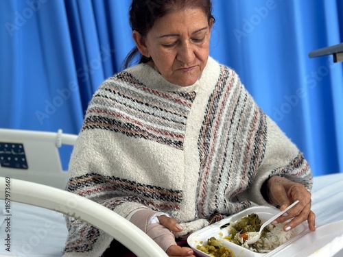 Female Patient Eating Meal While Sitting on Hospital Bed