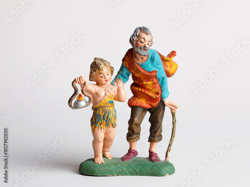 A small child guiding his blind grandfather -figurine