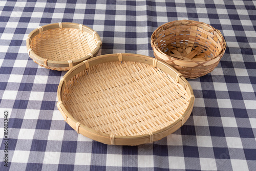 Arrangement of three bamboo baskets forming a silhouette of a face on checkered tablecloth