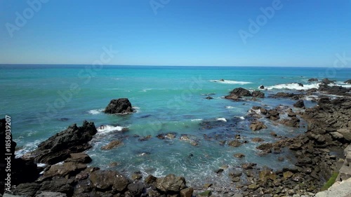 Rocky coastline with turquoise ocean under clear blue sky