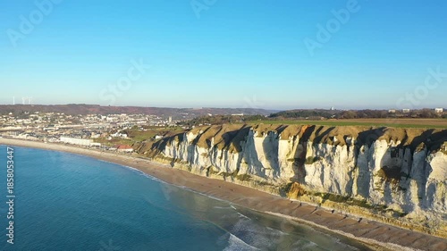 Aerial view of dramatic white chalk cliffs and sandy beach along the coastline of Fecamp, Normandy, France on a clear sunny day.