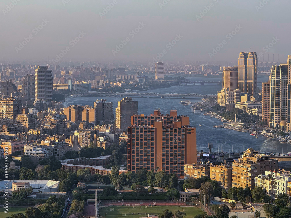 Obraz premium Cairo, Egypt - September 29, 2025: Nile River curves through modern high rise districts viewed from Cairo Tower