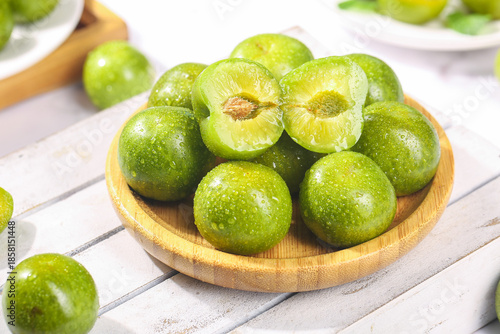 Fresh Green Sichuan Plums with Pit on Wooden Bowl