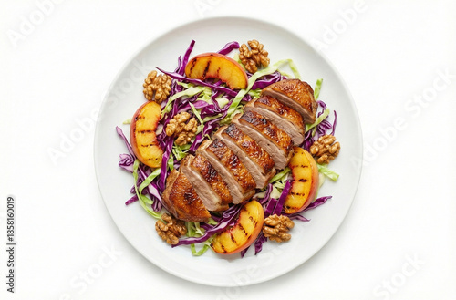 Sliced, juicy grilled duck with sapphire peaches, walnuts, and red cabbage salad on a white plate.