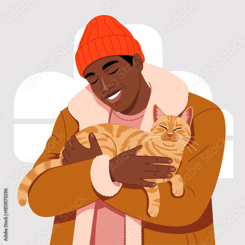 A joyful young man in a bright orange beanie and warm coat is happily holding a relaxed orange tabby cat, expressing a deep bond and affection between them.